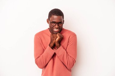 Beyaz arka planda izole edilmiş genç Afrikalı Amerikalı ellerini çenesinin altında tutuyor ve mutlu bir şekilde yan tarafa bakıyor..