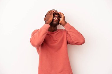 Beyaz arka planda izole edilmiş genç Afro-Amerikalı adam mutlu bir şekilde ellerini başının üstünde tutarak gülüyor. Mutluluk kavramı.