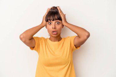 Genç melez kadın beyaz arka planda izole edilmiş şaşırmış ve şok olmuş..