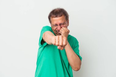 Middle aged indian man isolated on white background throwing a punch, anger, fighting due to an argument, boxing.