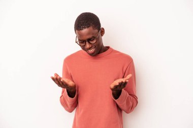 Beyaz arka planda izole edilmiş genç Afro-Amerikan bir adam elinde avuç içi bir şeyle kameraya teklif ediyor..