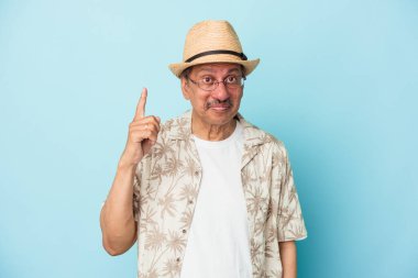 Senior indian man wearing summer clothes isolated on blue background Senior indian woman wearing a african costume isolated on white background having some great idea, concept of creativity.