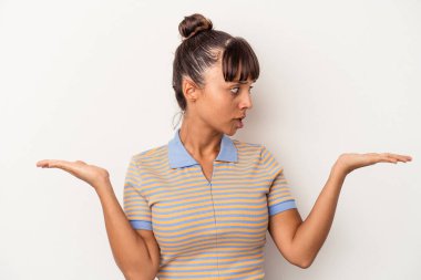 Beyaz arka planda soyutlanmış genç melez bir kadın. Kafası karışmış ve omuz silkiyor. Kopya alanını tutmak için..