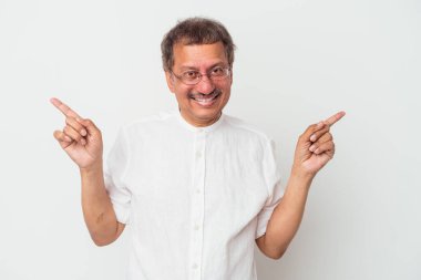 Middle aged indian man isolated on white background pointing to different copy spaces, choosing one of them, showing with finger.