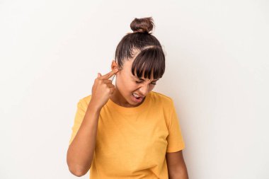 Genç melez kadın, beyaz arka planda izole edilmiş kulakları elleriyle kapatıyor..