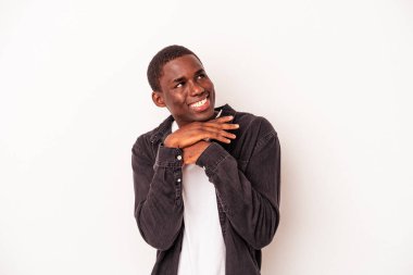 Beyaz arka planda izole edilmiş genç Afrikalı Amerikalı ellerini çenesinin altında tutuyor ve mutlu bir şekilde yan tarafa bakıyor..