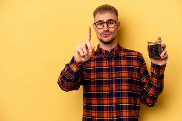 Giovane Uomo Caucasico Possesso Caffè Vaso Isolato Sfondo Giallo Mostrando — Foto Stock