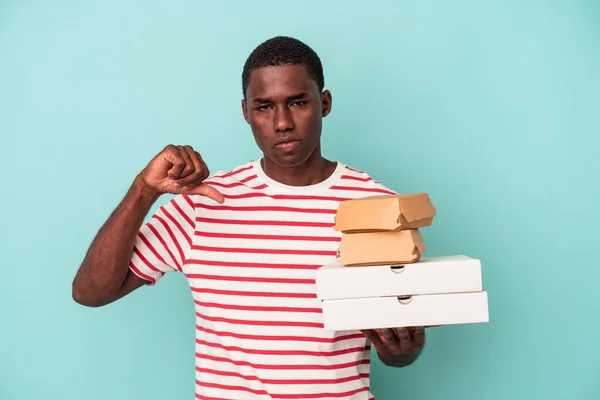 Mladý Afroameričan Držící Pizzu Hamburgery Izolované Modrém Pozadí Ukazující Nepřátelské — Stock fotografie