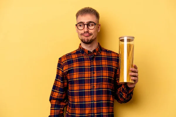 Hombre Caucásico Joven Sosteniendo Tarro Spaghettis Aislado Sobre Fondo Amarillo —  Fotos de Stock