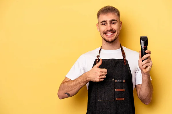 Young Caucasian Hairdresser Man Isolated Yellow Background Smiling Raising Thumb — Stock Photo, Image