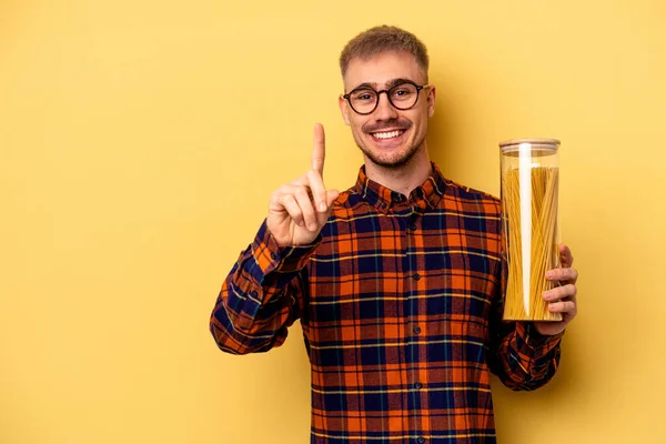 Young Caucasian Man Holding Spaghettis Jar Isolated Yellow Background Showing — Stock fotografie