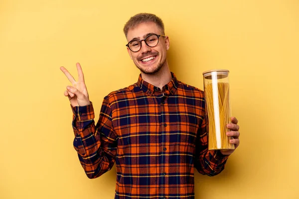 Young Caucasian Man Holding Spaghettis Jar Isolated Yellow Background Joyful — Stock fotografie
