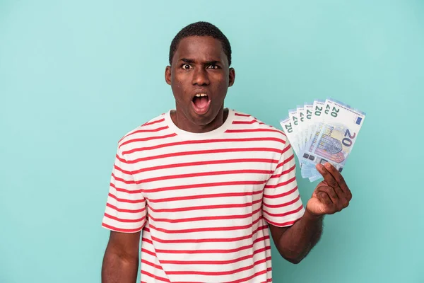 Young African American Man Holding Bank Notes Isolated Blue Background — Stock Photo, Image