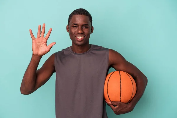 Joven Afroamericano Jugando Baloncesto Aislado Sobre Fondo Azul Sonriente Alegre — Foto de Stock