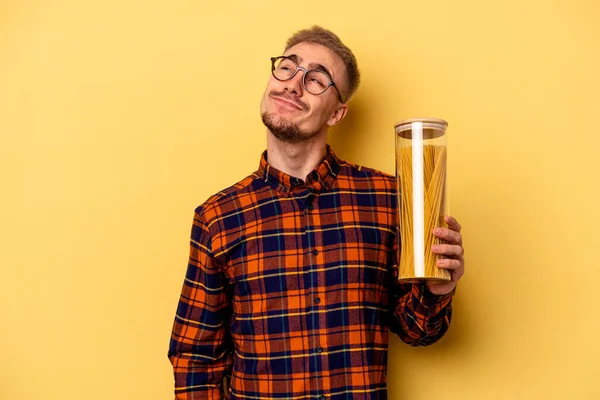 Young Caucasian Man Holding Spaghettis Jar Isolated Yellow Background Dreaming — Stock fotografie