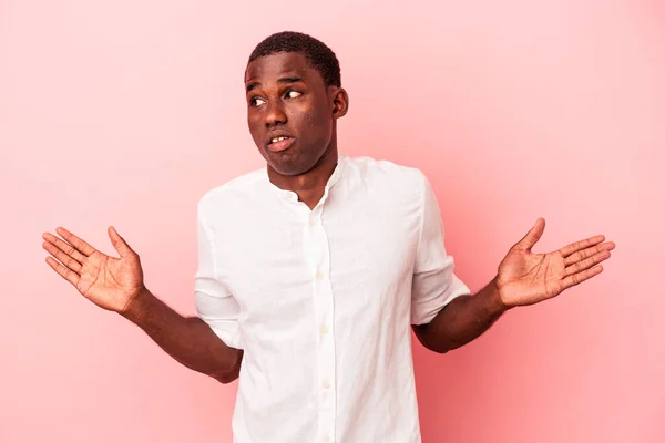 Ung Afrikansk Amerikansk Man Isolerad Rosa Bakgrund Förvirrad Och Tveksam — Stockfoto