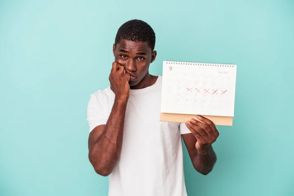 Jonge Afro Amerikaanse Man Met Een Kalender Geïsoleerd Blauwe Achtergrond — Stockfoto