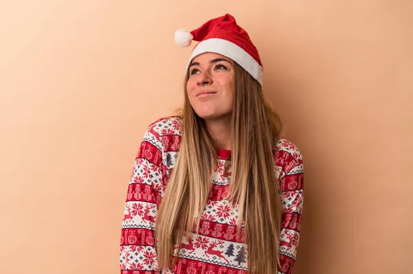 目標と目的を達成することを夢見てベージュの背景に隔離されたクリスマスを祝う若いロシアの女性 — ストック写真