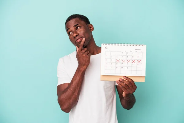 Jonge Afro Amerikaanse Man Met Een Kalender Geïsoleerd Blauwe Achtergrond — Stockfoto