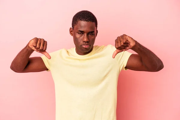 Joven Afroamericano Aislado Sobre Fondo Rosa Mostrando Gesto Aversión Pulgares —  Fotos de Stock