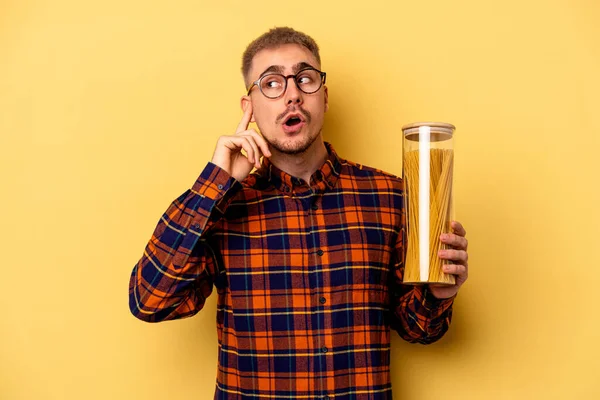 Young Caucasian Man Holding Spaghettis Jar Isolated Yellow Background Trying — Stock fotografie
