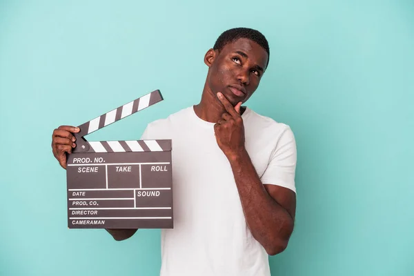 Jonge Afro Amerikaanse Man Houdt Clapperboard Geïsoleerd Blauwe Achtergrond Kijken — Stockfoto