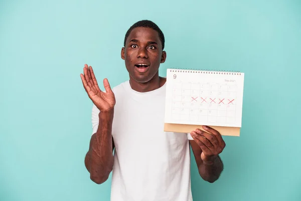 Jonge Afro Amerikaanse Man Met Een Kalender Geïsoleerd Blauwe Achtergrond — Stockfoto