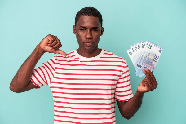 Mladý Afroameričan Držící Bankovky Izolované Modrém Pozadí Ukazující Gesto Nelibosti — Stock fotografie