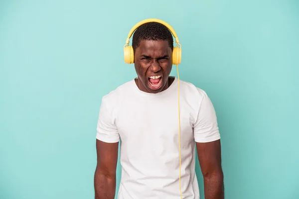 Young African American Man Listening Music Isolated Blue Background Screaming — ストック写真