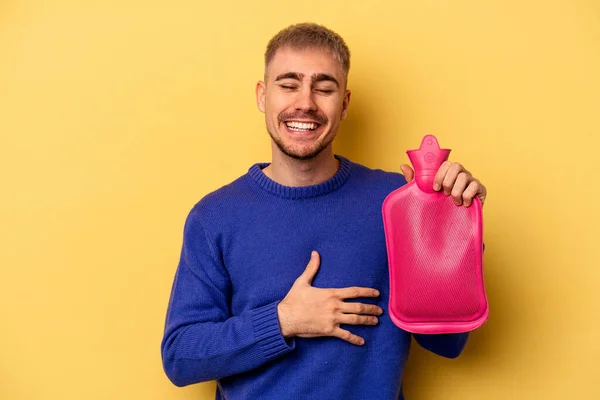 Young Caucasian Man Holding Water Bag Isolated Yellow Background Laughing — Foto Stock