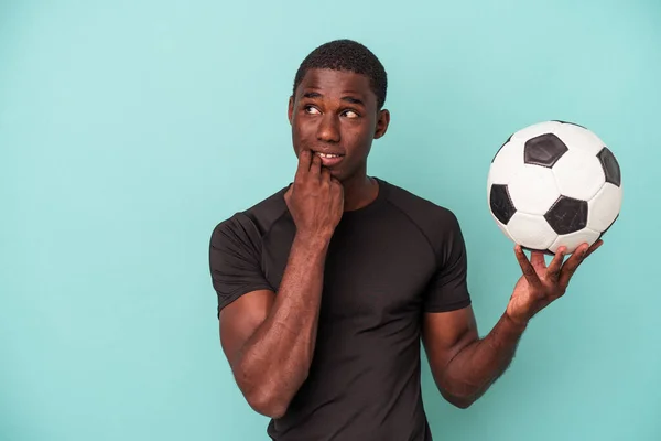 Joven Hombre Afroamericano Jugando Fútbol Aislado Sobre Fondo Azul Relajado —  Fotos de Stock