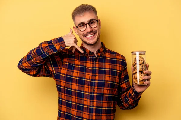 Young Caucasian Man Holding Cookies Jar Isolated Yellow Background Showing — Foto de Stock