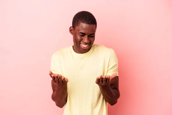 Mladý Africký Američan Izolovaný Růžovém Pozadí Drží Něco Dlaněmi Nabízí — Stock fotografie