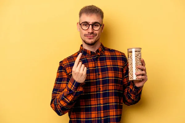 Young Caucasian Man Holding Chickpeas Isolated Yellow Background Pointing Finger — Photo