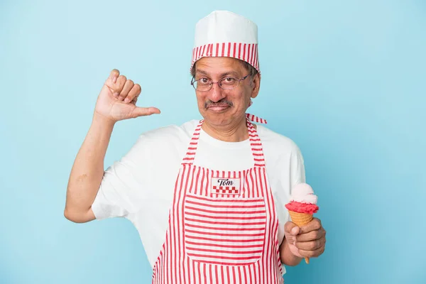Senior american ice cream man holding an ice cream isolated on blue background feels proud and self confident, example to follow.