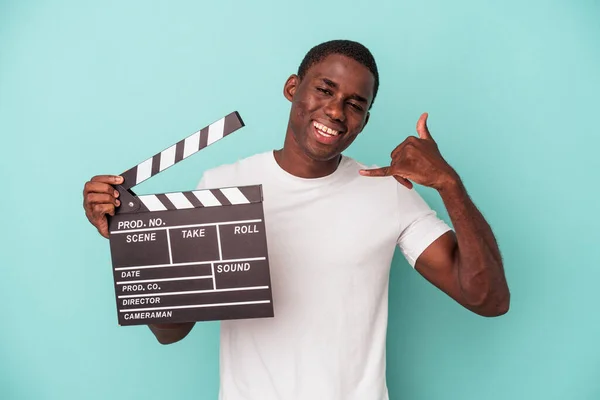 Jonge Afro Amerikaanse Man Houdt Clapperboard Geïsoleerd Blauwe Achtergrond Toont — Stockfoto