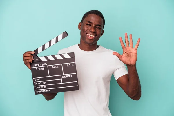 Jonge Afro Amerikaanse Man Met Clapperboard Geïsoleerd Blauwe Achtergrond Lachend — Stockfoto