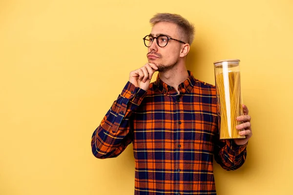 Young Caucasian Man Holding Spaghettis Jar Isolated Yellow Background Looking — Stock fotografie