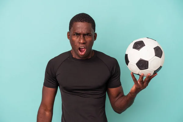 Młody Afroamerykanin Gra Piłkę Nożną Odizolowany Niebieskim Tle Krzyczy Bardzo — Zdjęcie stockowe