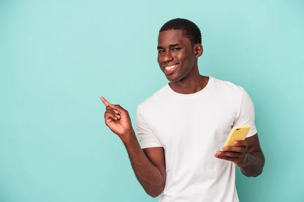 Young African American Man Holding Mobile Phone Isolated Blue Background — Stock Photo, Image