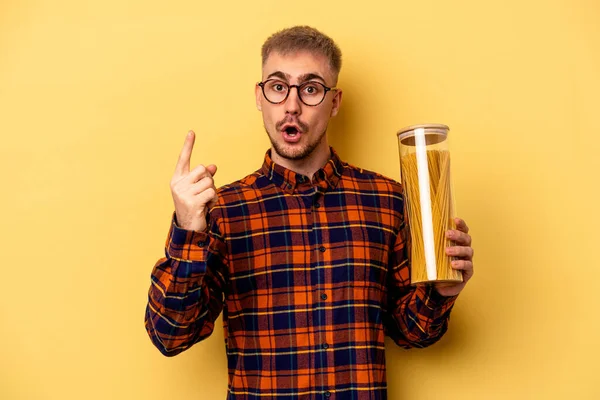 Young Caucasian Man Holding Spaghettis Jar Isolated Yellow Background Having — Stock fotografie