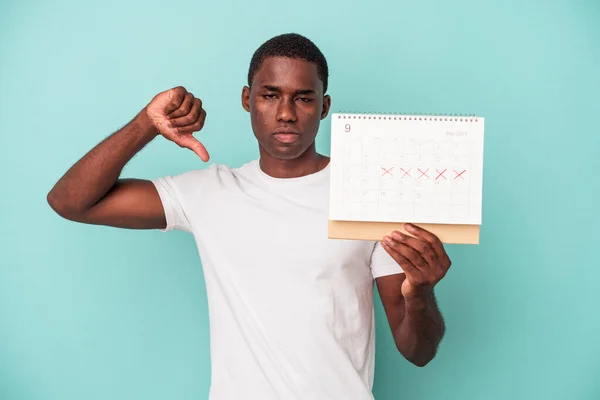 Mladý Afroameričan Který Drží Kalendář Izolovaný Modrém Pozadí Ukazuje Gesto — Stock fotografie