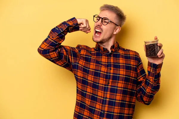Young Caucasian Man Holding Coffee Jar Isolated Yellow Background Raising — Stock fotografie