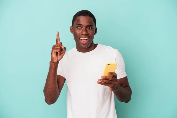 Young African American Man Holding Mobile Phone Isolated Blue Background — Stock Photo, Image