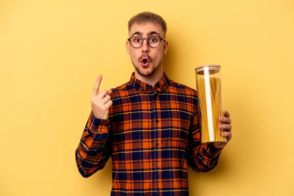 Young Caucasian Man Holding Spaghettis Jar Isolated Yellow Background Having — Fotografia de Stock
