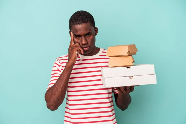 Mladý Afroameričan Drží Pizzy Hamburgery Izolované Modrém Pozadí Ukazující Prstem — Stock fotografie
