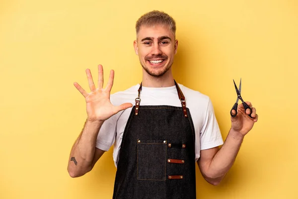 Young Caucasian Hairdresser Man Holding Scissors Isolated Yellow Background Smiling — Stock fotografie
