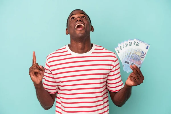 Jonge Afro Amerikaanse Man Houdt Een Bankbiljet Geïsoleerd Blauwe Achtergrond — Stockfoto