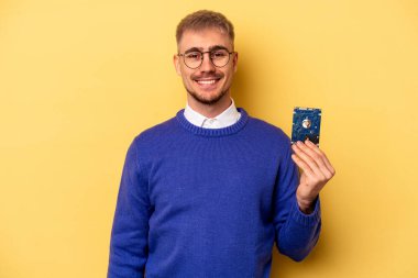 Young computer man isolated on yellow background happy, smiling and cheerful.
