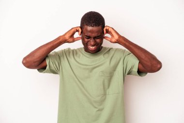 Genç Afrikalı Amerikalı adam beyaz arka planda izole edilmiş kulakları elleriyle kapatıyor..
